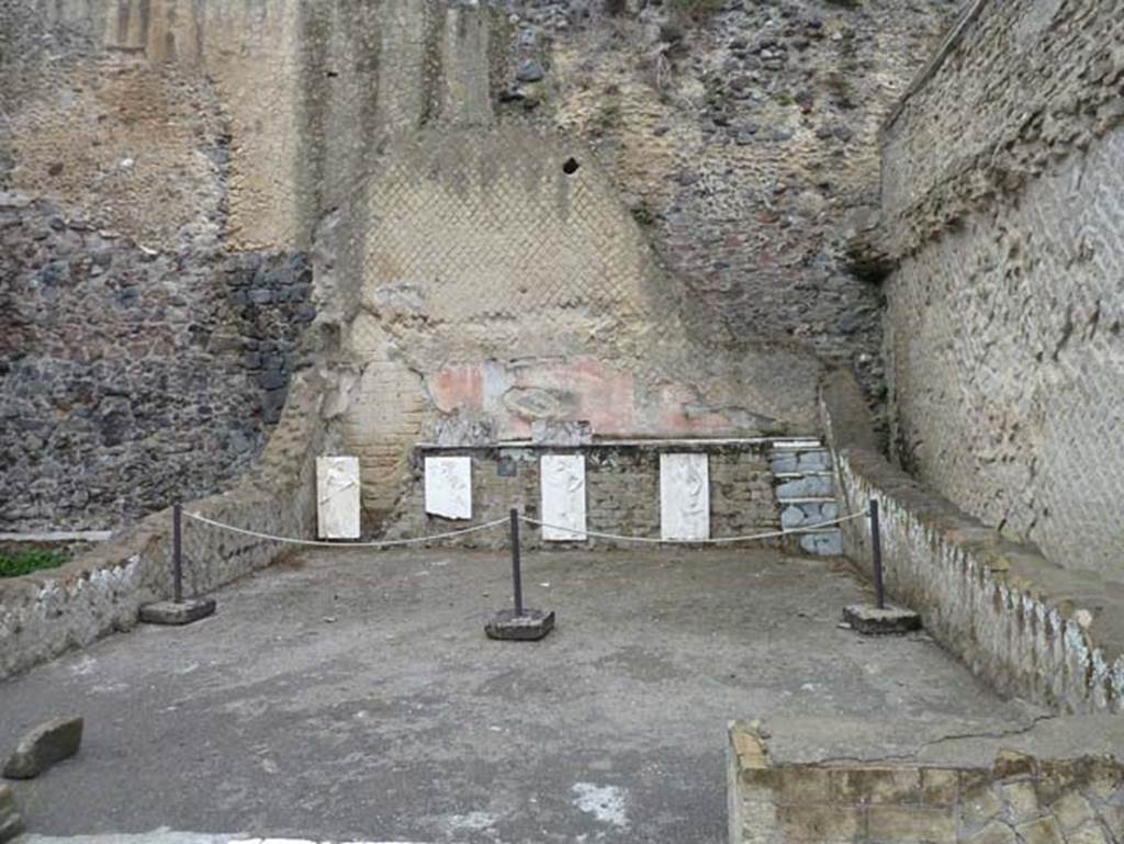 Herculaneum, September 2015. Sacred Area terrace, looking north in the shrine of the Four Gods. The copies of the reliefs are thought to be hanging in their original position, fastened to the front wall of the podium.  The originals, now in Naples Museum, were recently found on the ancient beachfront, no doubt thrown there by the force of the eruption, and show Minerva, Neptune, Mercury and Vulcan.